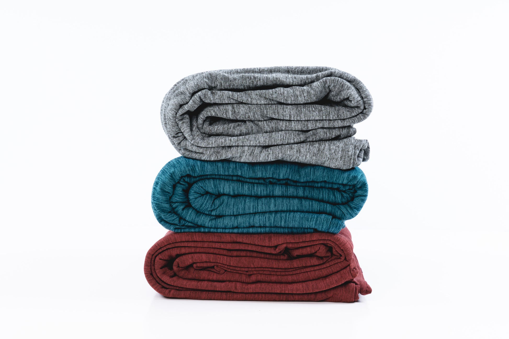 three hug wraps folded up and stacked on top of one another (grey, green and red colors)