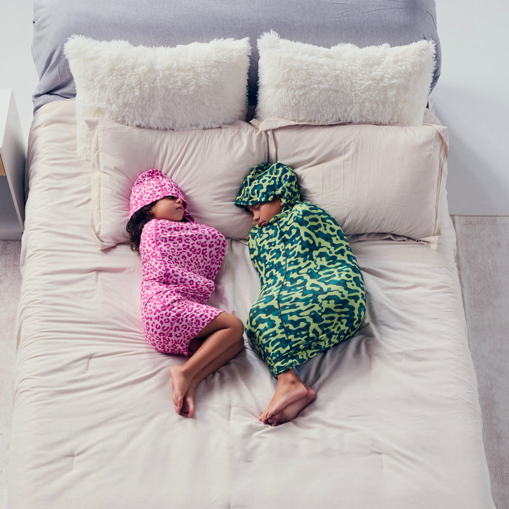 Kids sleeping in pink and camo color sleep pod mini in bed