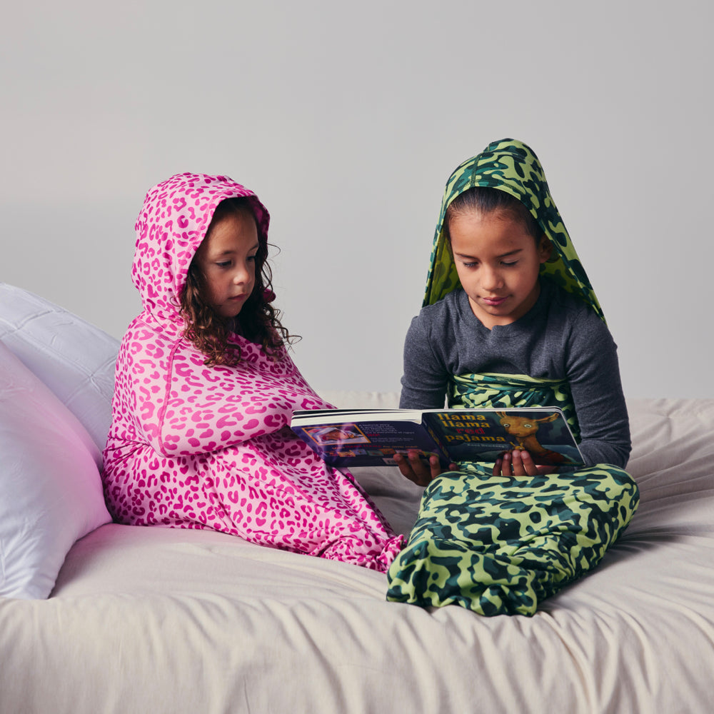 Kids in sleep pod on bed reading a book
