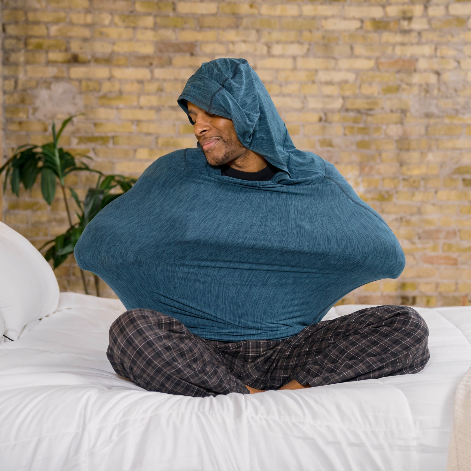 Man in sleep pod mini sitting on bed