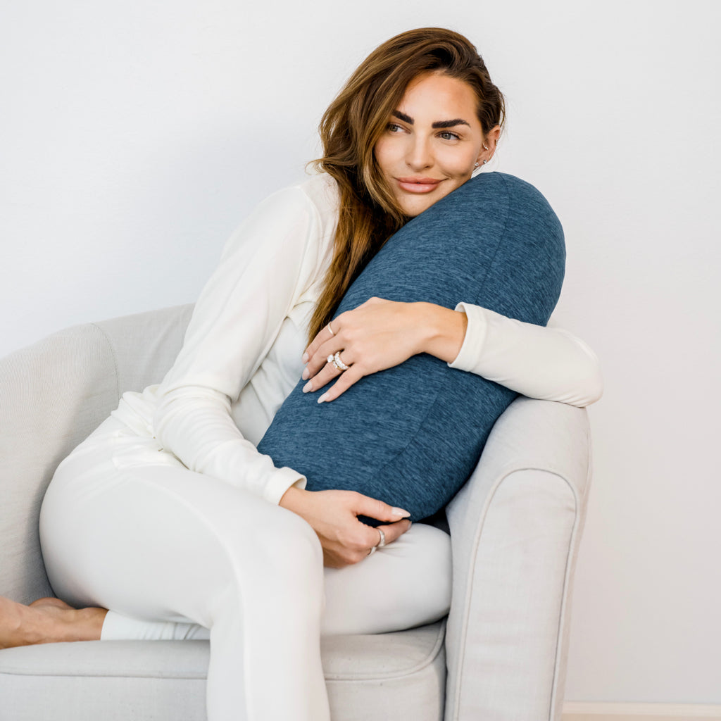 woman holding  Pod Pillow™ with teal colored pillowcase on