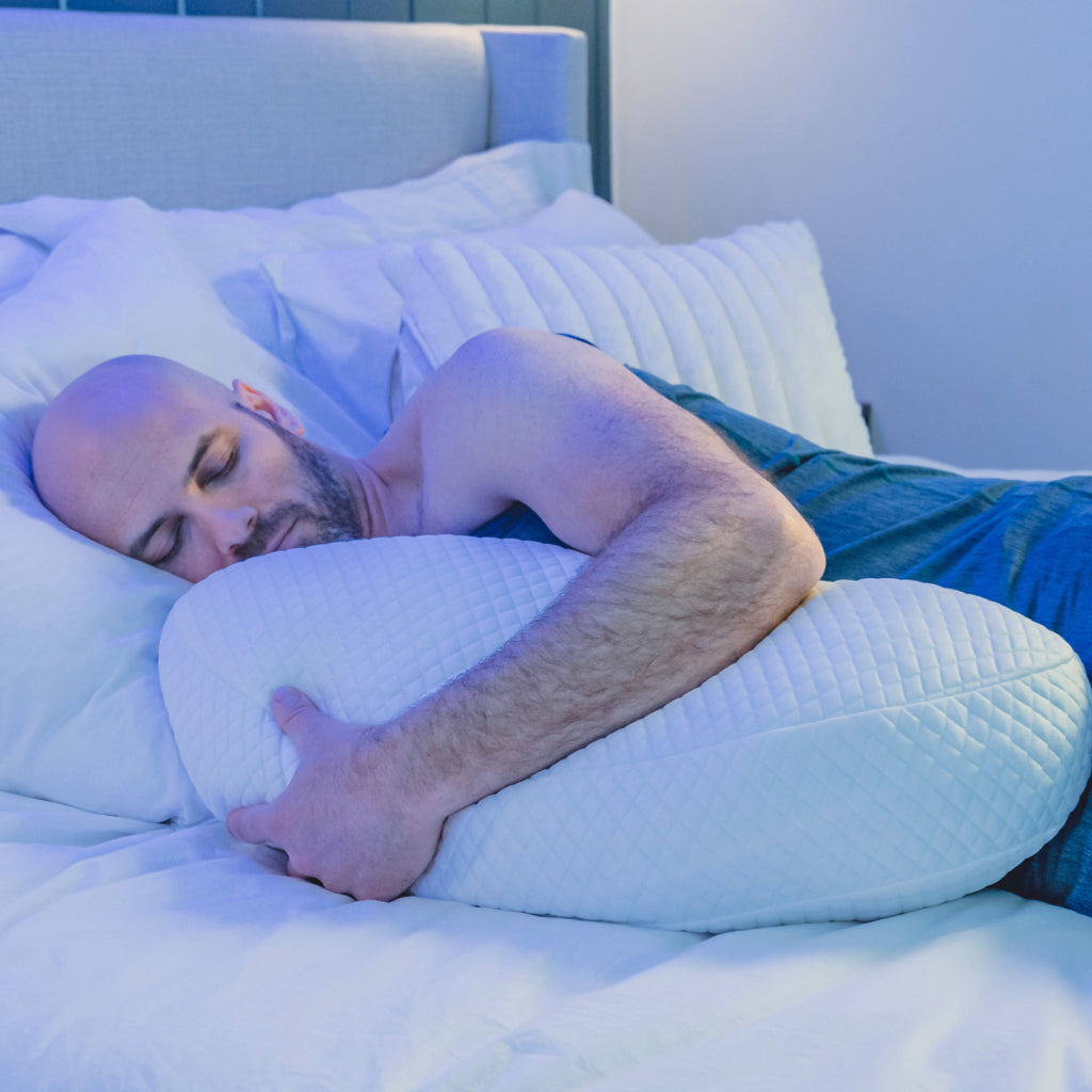 man sleeping in sleep pod holding Pod Pillow™