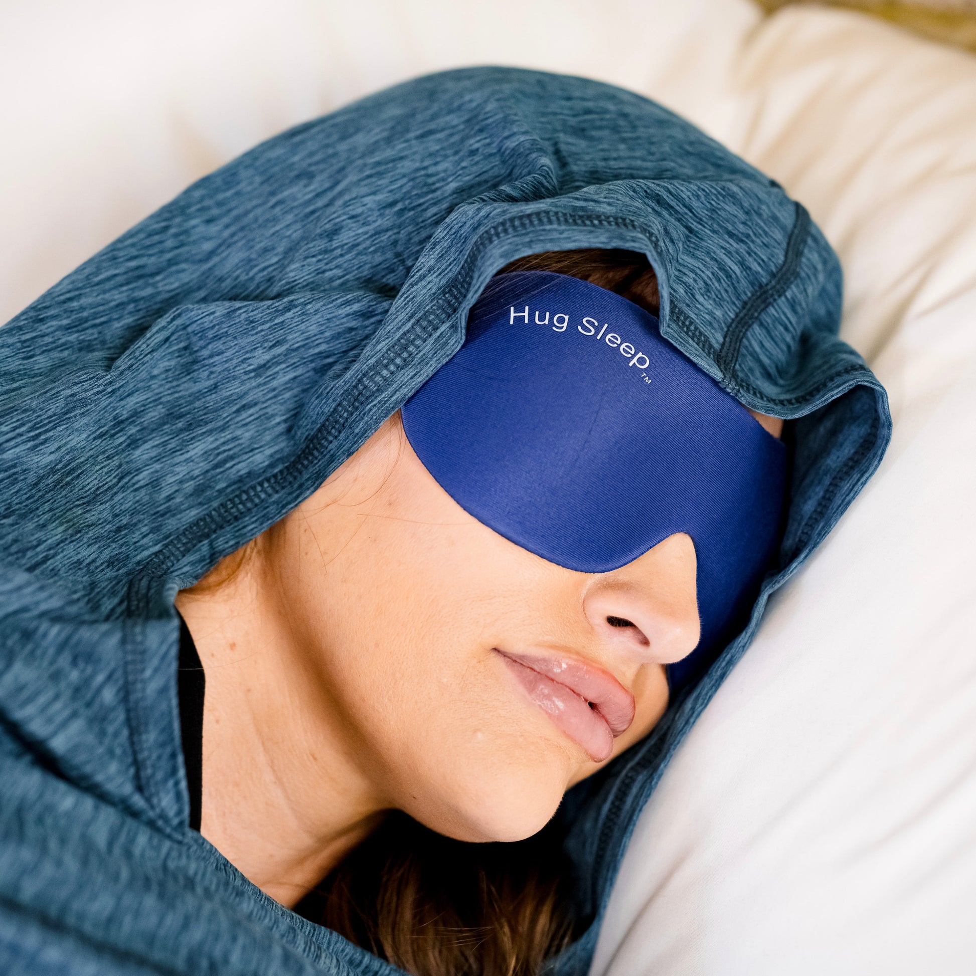 woman laying in bed with hood and sleep mask on