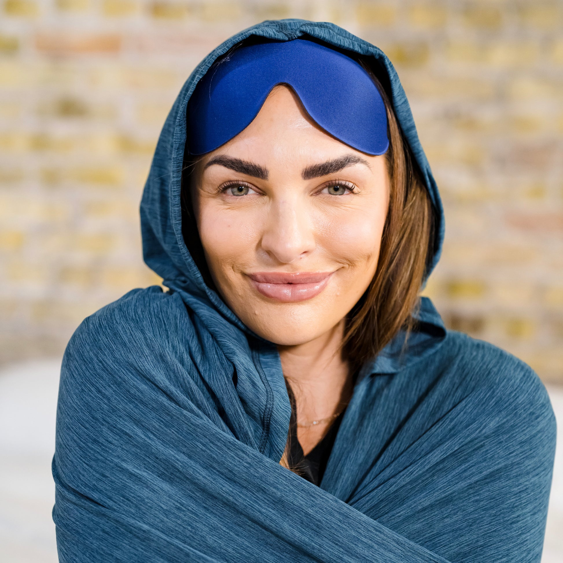 woman in bed in a hug wrap™ with hug sleep mask on