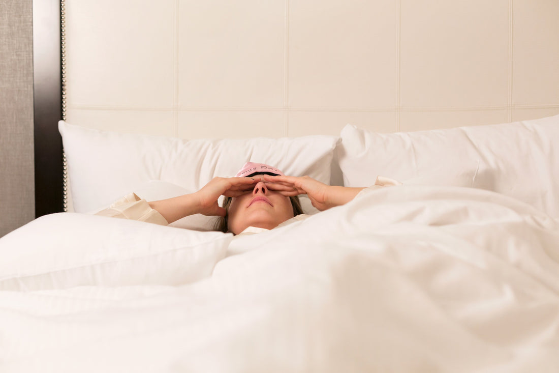 Image of woman in bed unable to sleep, frustrated 