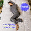 Woman in graphite color sleep pod in bed -  badge that says "BOGO 50% OFF ALL SLEEP PODS" and "OUR SPRING SALE IS LIVE"