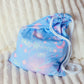 cosmic blue pattern draw string bag laying on a mattress