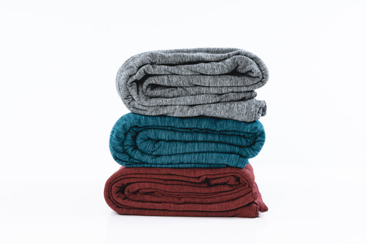 three-hug-wraps-folded-up-and-stacked-on-top-of-one-another-grey-green-and-red-colors