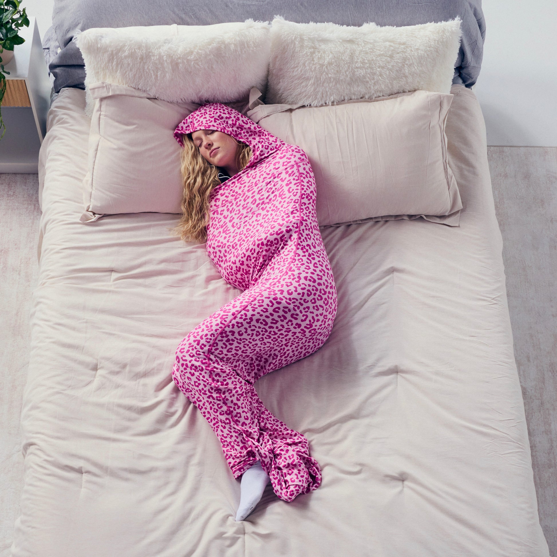 woman wearing leopard pink Sleep pod on bed