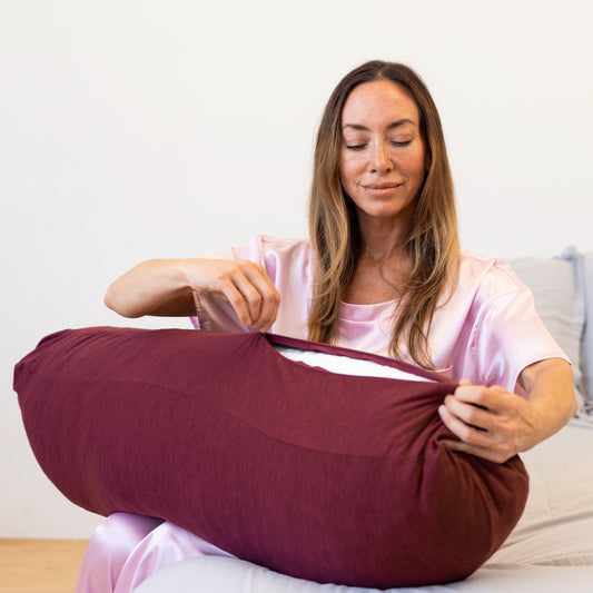 woman-putting-on-ruby-pillow-case-onto-body-pillow