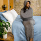 woman sitting on side of bed with hooded sleep pod move on