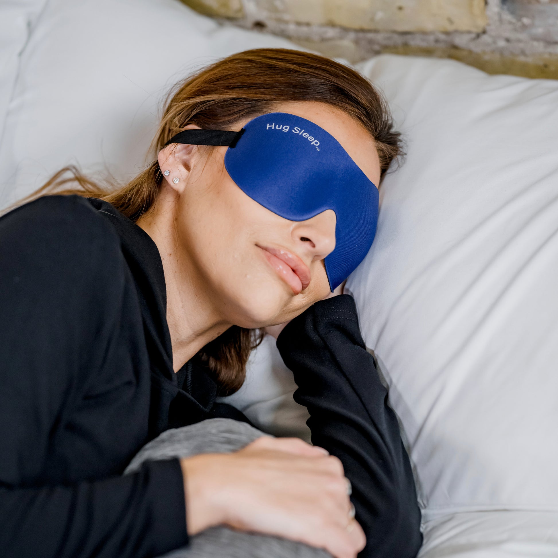 woman in bed with hug sleep mask on