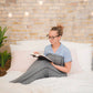 woman laying in bed with sleep pod reading a book
