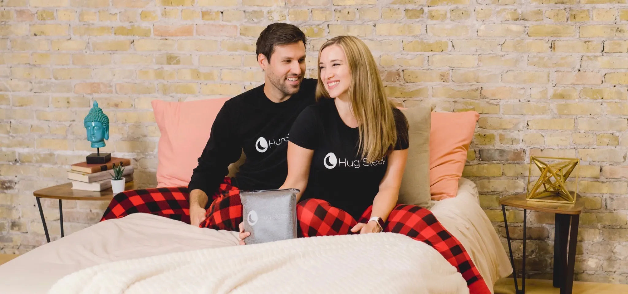 Matt and Angie sitting on bed with Hug Sleep Pod