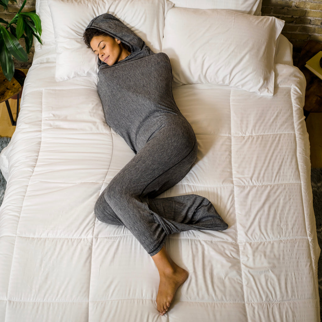 Woman in Sleep Pod Hood in bed laying down
