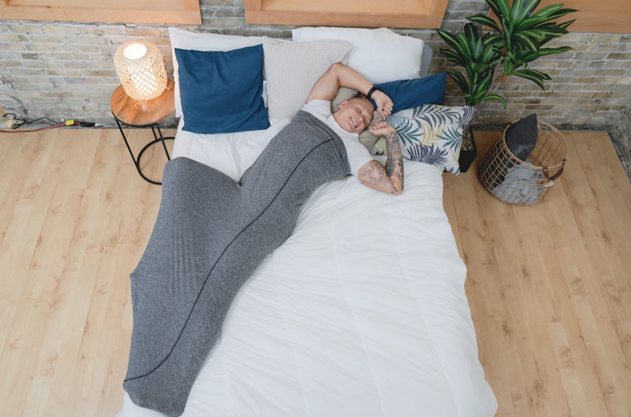 Man waking up in sleep pod laying on bed